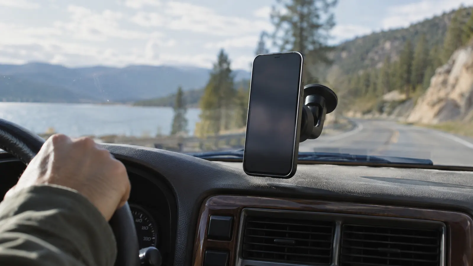 A phone held on a magnetic dashboard mount in an older SUV, seen from the driver's seat